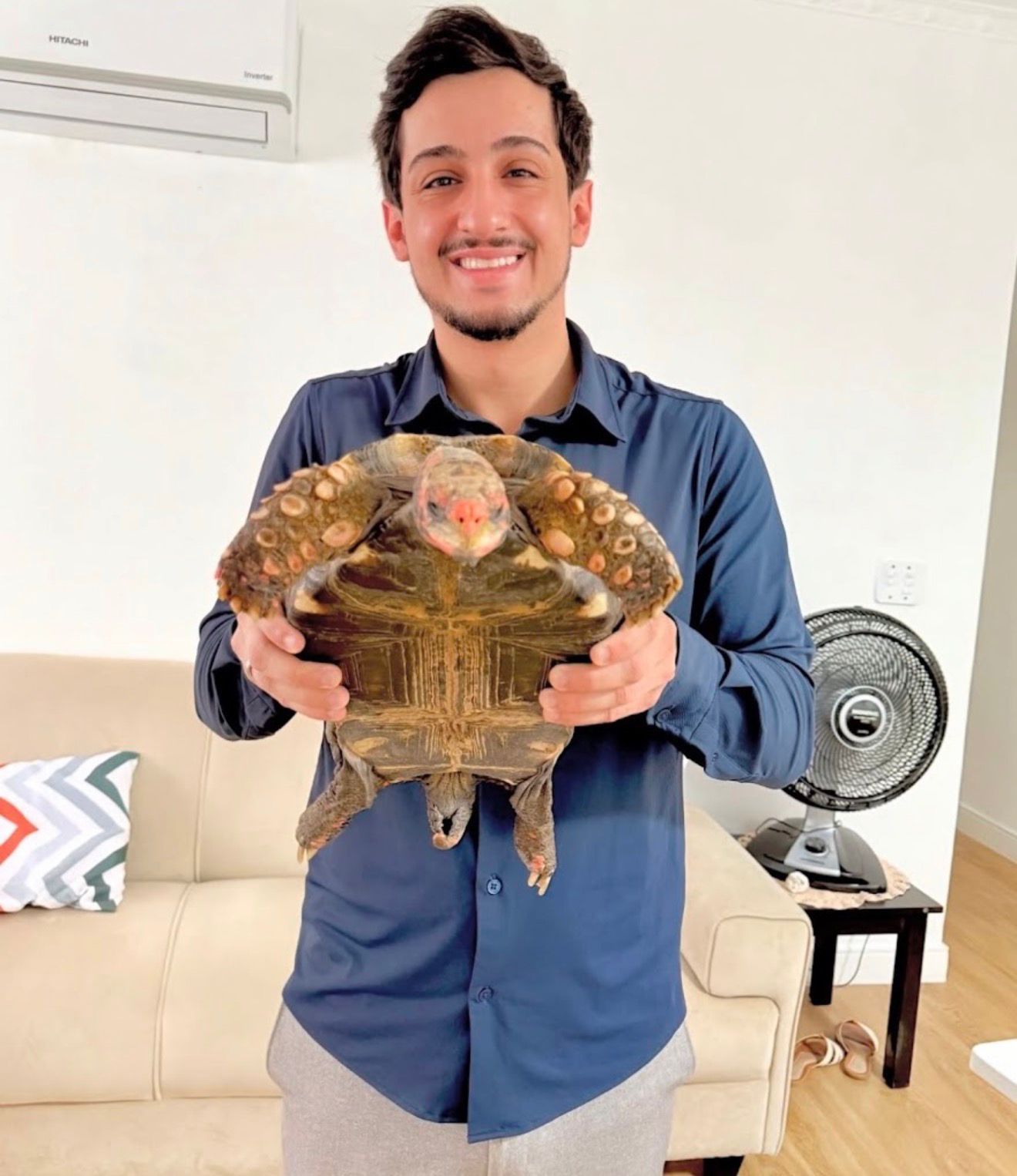 Dr. Pedro Filetti segurando um jabuti durante consulta em casa